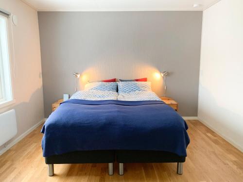 FjordgårdSegla Guesthouse - Lovely sea view的一间卧室配有一张带蓝色棉被的床