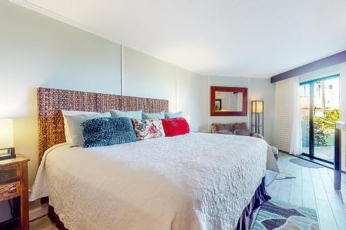 利胡埃Kauai Beach Resort #3124的一间卧室配有一张带色彩缤纷枕头的大床