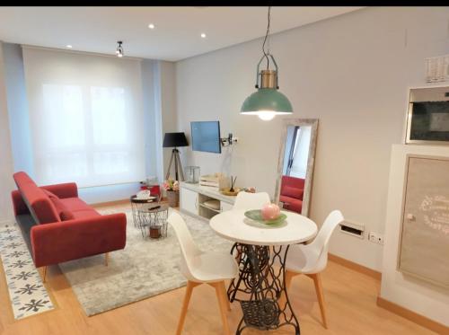 奥维多Loft Oviedo的客厅配有桌子和红色椅子