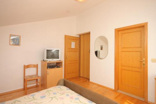 博扎瓦Double Room Bozava 8100a的一间设有床、电视和门的房间