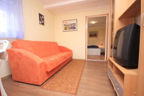 洛夫兰Apartments and rooms by the sea Medveja, Opatija - 2305的客厅配有橙色沙发和电视