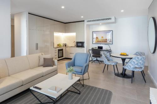黄金海岸Meriton Suites Surfers Paradise的客厅配有沙发、椅子和桌子