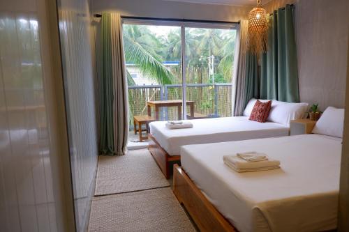卢纳将军城Lubihan Siargao的酒店客房设有两张床和窗户。