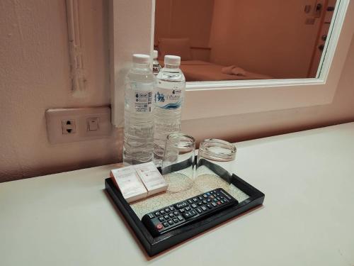 合艾亚细亚大酒店的一个带遥控器和一瓶水的托盘