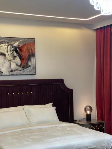 多哈MK Resort的卧室配有一张床,并画有一幅马