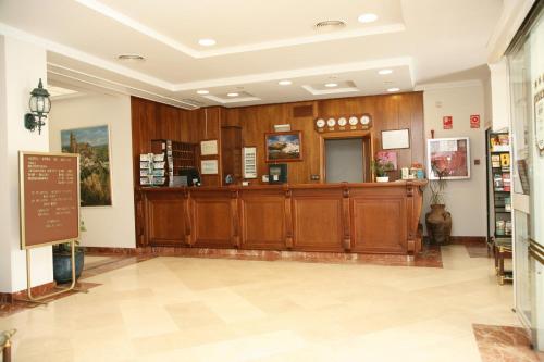 阿尔科斯-德拉弗龙特拉佩尼亚德阿科斯酒店的大堂设有木制橱柜和现金登记册