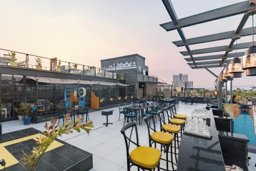 乌代浦地平线酒店的一个带桌椅的屋顶露台和游泳池