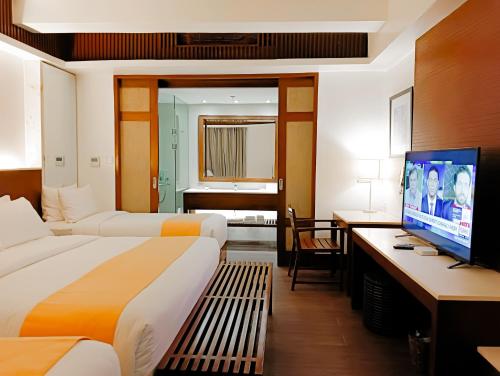 长滩岛White Sand Boracay的酒店客房设有两张床和一台平面电视。