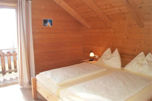 PöllaubergFerienhaus mit Panoramaausblick und Sauna - 3 SZ的卧室配有木墙内的一张床