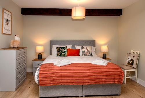 K2Cottages的一间卧室配有一张带红色枕头的大床