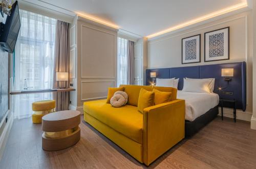 里斯本Eurostars Lisboa Baixa的酒店客房设有床和黄色沙发