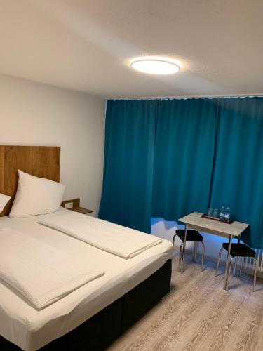 费尔德基希Hotel am Bahnhof的一间卧室配有一张床和一张桌子及椅子