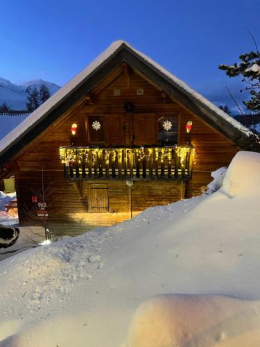 德沃吕伊Chalet La joue du Loup的雪上覆盖着雪上的小屋,上面有圣诞灯