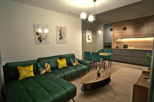 比亚瓦波德拉斯卡Apartament Witold的客厅配有绿色沙发和桌子