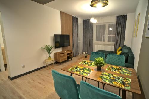 比亚瓦波德拉斯卡Apartament Witold的客厅配有桌椅和电视。
