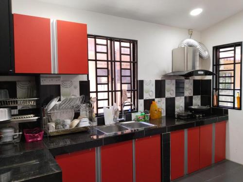 怡保Homestay YatiMizi (Bungalow Station 18, Ipoh)的一间带红色橱柜和水槽的厨房