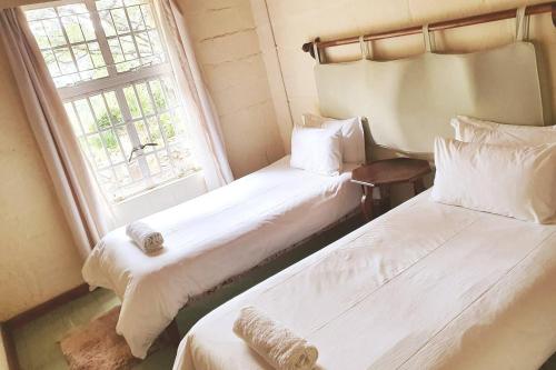 JuliasdaleRemarkable 3-Bed Cottage in Nyanga的带窗户的客房内的两张床