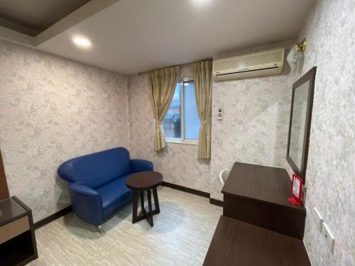 台北苓旅-站前 Lin Inn TMS的客厅配有蓝色椅子和桌子