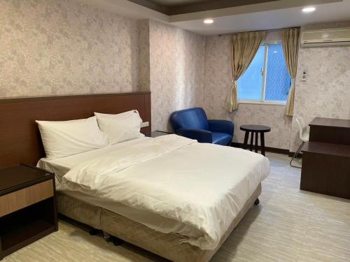 台北苓旅-站前 Lin Inn TMS的酒店客房,配有一张床和一张蓝色椅子