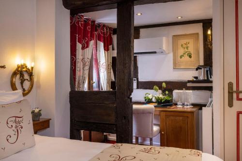 科尔马Hotel Restaurant Le Maréchal - Teritoria的一间带一张床的房间和一间带桌子的厨房
