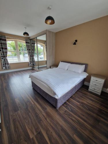 阿比菲尔Mountmahon House的一间卧室设有一张大床,铺有木地板。