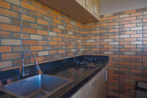 塔巴南Gama’s Villa的厨房设有水槽和砖墙