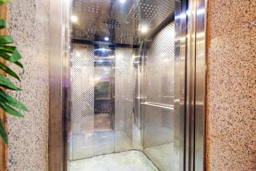 吉达OYO 589 Lavina House的步入式淋浴间,设有玻璃门