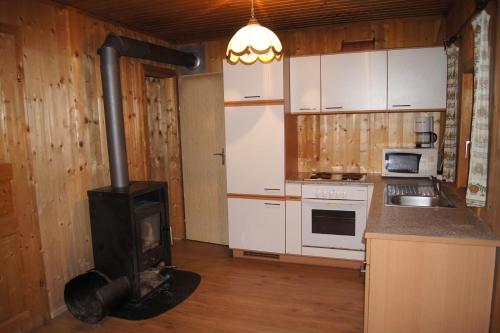 Rossleithen布兰特纳度假木屋的客房内的厨房配有燃木炉