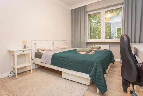 比亚韦斯托克Duży apartament w centrum przy rynku的一间卧室配有一张床、一张书桌和一个窗户。