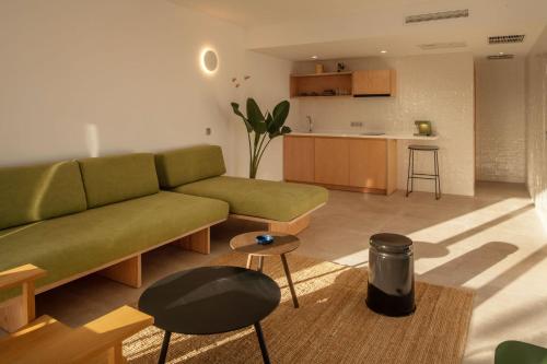 卡门港Barcarola Club的一间带绿色沙发的客厅和一间厨房