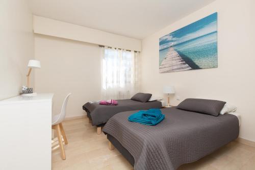 戛纳Spacieux 3 p pour 6 Cannes proche plages et Palais的一间卧室设有两张床,墙上挂着一幅画