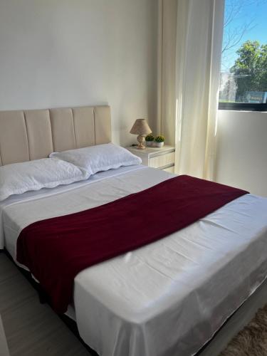 库里提巴Lindo apartamento的卧室内的一张大床,设有窗户