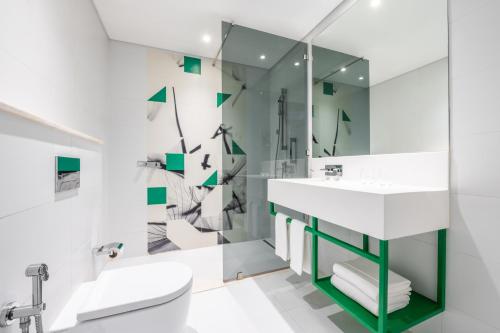 迪拜Studio M Arabian Plaza Hotel & Hotel Apartments的一间带水槽、卫生间和镜子的浴室