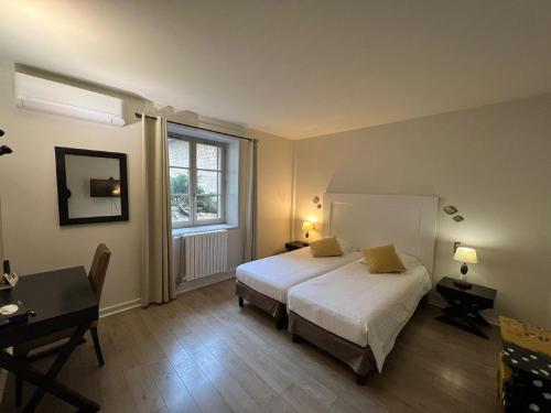 昂斯圣罗曼洛基斯酒店-餐厅的一间卧室配有一张床、一张书桌和一个窗户。
