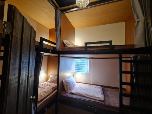 曼谷Non House Hostel บ้านนอนโฮสเทล的带窗户的客房内的两张双层床