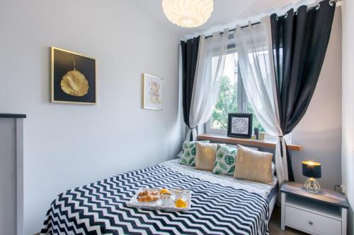 华沙ClickTheFlat Avenue Place Apart Rooms的一间卧室配有一张床,上面放着一个食物托盘