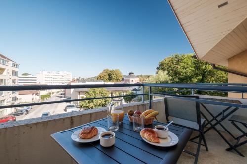 隆勒索涅温泉浴场公寓酒店的阳台上的一张桌子上放着两盘食物