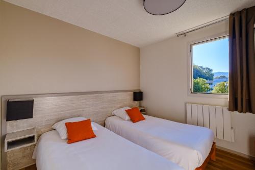 隆勒索涅温泉浴场公寓酒店的带窗户的客房内的两张床