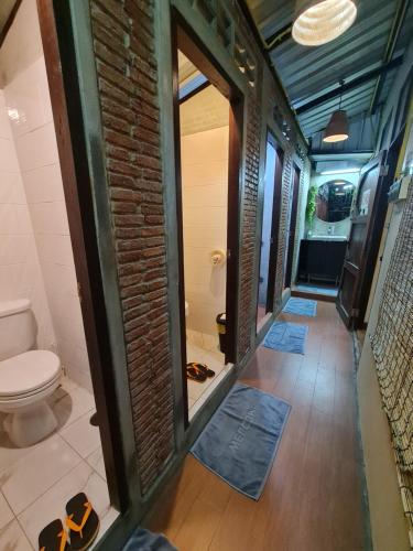 曼谷Non House Hostel บ้านนอนโฮสเทล的一间带卫生间和砖墙的浴室