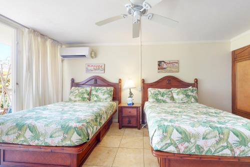 卡帕阿Islander on the Beach 111的一间卧室配有两张床和吊扇