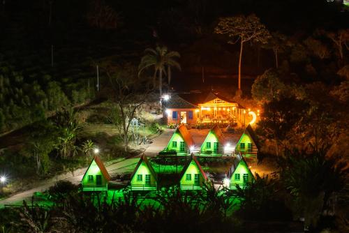 Caparaó VelhoPousada Recanto da Lua的夜晚有绿灯的房屋