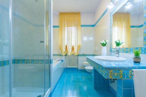 马帝斯兹罗Appartamento Bellaria Luxury - MyHo Casa的蓝色的浴室设有水槽和淋浴