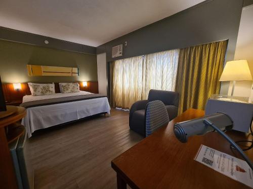 圣保罗Flat Borges Lagoa Ibirapuera c/ garagem UH508的配有一张床和一张书桌的酒店客房
