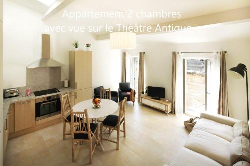 阿尔勒Holiday in Arles -Appartement du Théâtre Antique的厨房以及带桌椅的起居室。