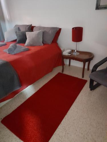 马萨尔福恩Gozo Marsalforn的一间卧室配有红色的床和红色地毯
