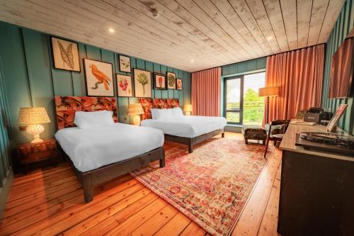 阿斯隆Glasson LakeHouse的酒店客房带两张床、书桌以及一间客房。
