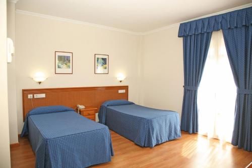 阿尔科斯-德拉弗龙特拉佩尼亚德阿科斯酒店的客房设有两张床和窗户。