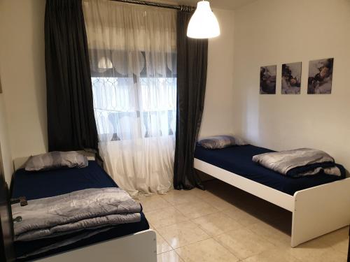 安曼Dair Ghbar 2-bedrooms unit的卧室在窗户前配有两张床