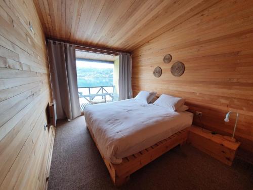 卡斯特鲁Hotel & Café Bauda的木制客房的一张床位,设有窗户