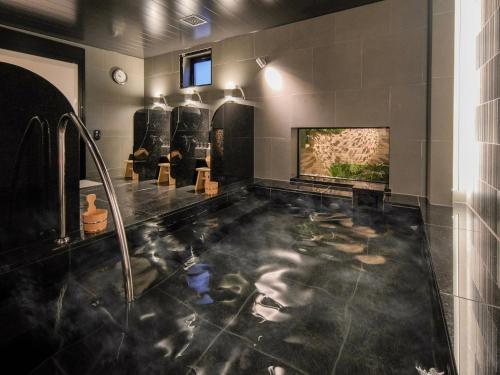 东京Super Hotel Premier Ikebukuro Natural Hot Spring的一间带水景浴缸的浴室